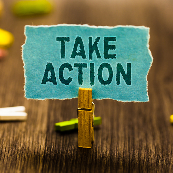 photo of clothespin holding piece of paper with "Take Action" printed on it