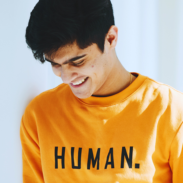 Photo of smiling person with "human" written on their shirt.