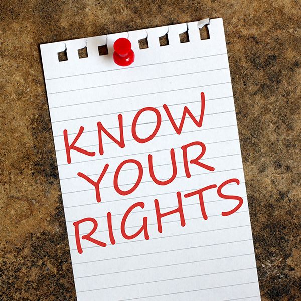 Photo of paper with "Know Your Rights" written on it and pushpinned to cork background