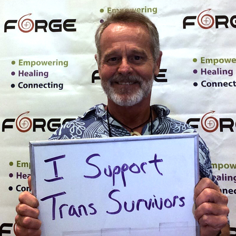 one smiling person holding a sign saying 'I Support Trans Survivors' in front of a FORGE logo backdrop